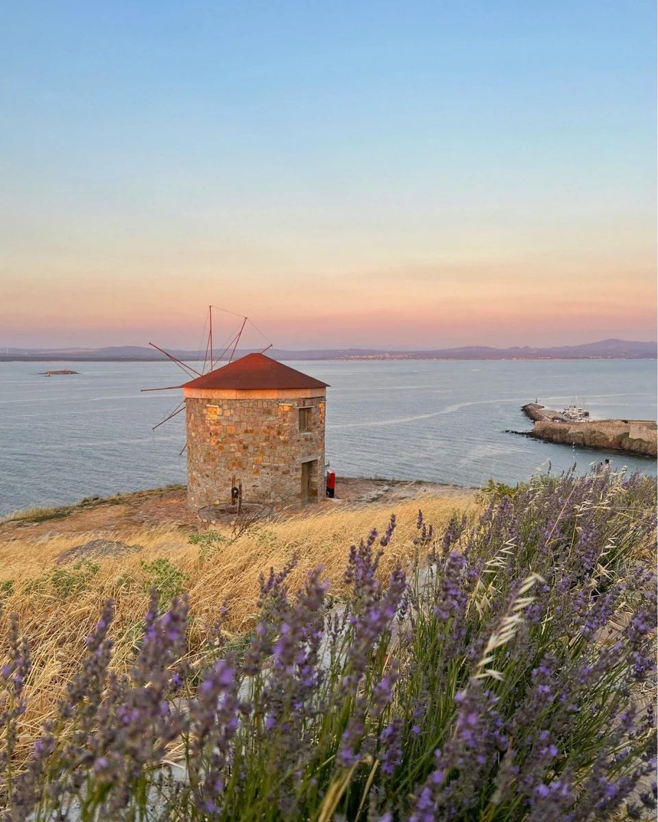 A stone windmill on Bozcaada beneath a softly coloured sky