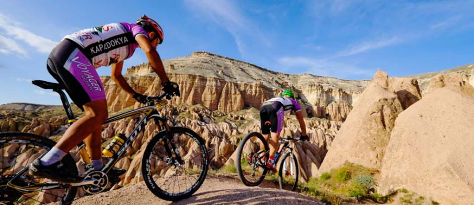 A cyclist winding through Cappadocia's towering rock formations