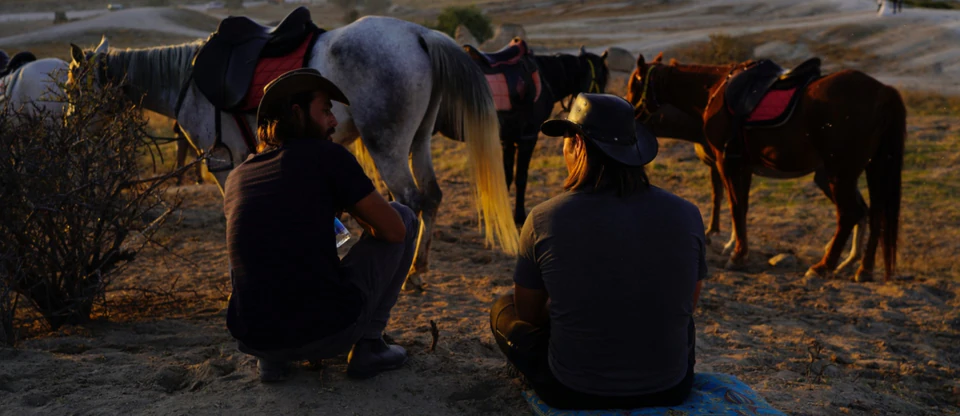 Horseback riders crossing Cappadocia's volcanic valleys